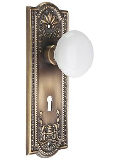 an ornate door handle with a white ball on it