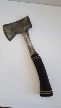 an old hammer is laying on top of a white surface with wood trimmings