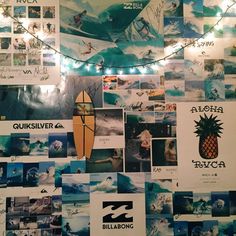 a wall covered in pictures and lights with a surfboard hanging from the ceiling next to it