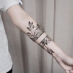 a woman's arm with flowers and leaves on it