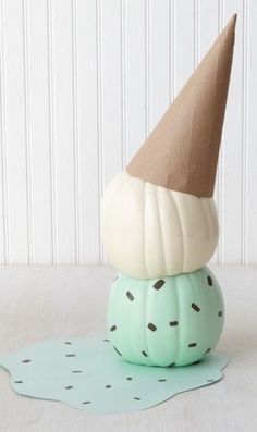 a paper hat sitting on top of a green pumpkin with polka dot dots around it