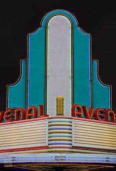 the marquee for avenue theatre is brightly lit up at night with bright colors