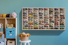 a room with blue walls and toy cars on the shelves