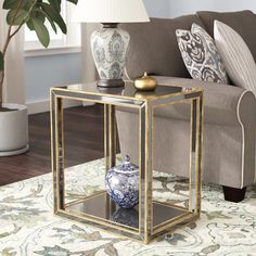 a living room with a couch, table and vase on the floor in front of it