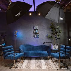 a living room with blue couches and umbrellas