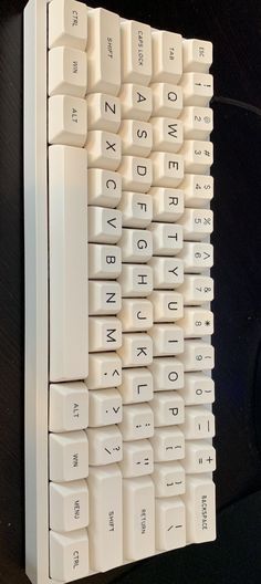 a white computer keyboard sitting on top of a table