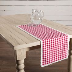 a red and white checkered table runner on top of a wooden dining room table