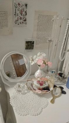 a white dresser topped with lots of glass vases filled with different types of flowers