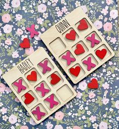 two wooden magnets with hearts and crosses on them sitting next to each other in front of flowers