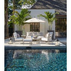 an outdoor lounge area next to a swimming pool