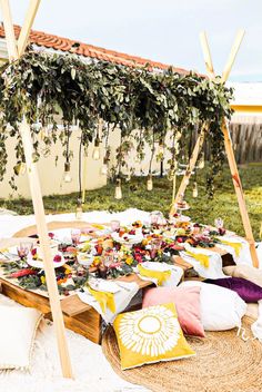 an outdoor picnic with food and flowers on the table for guests to eat in it