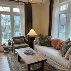 a living room with two couches and a coffee table in front of large windows