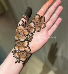 a woman's hand with henna tattoos on it