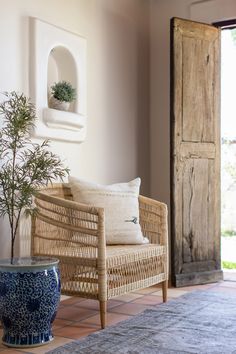 a wicker chair sitting next to a potted plant