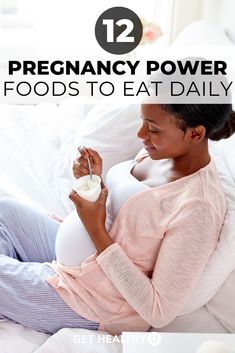 a pregnant woman sitting on a bed with her stomach exposed and holding a bottle of milk