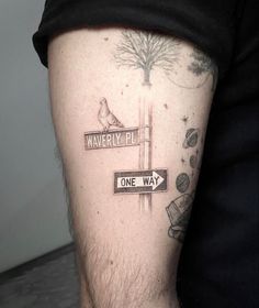 a man's leg with two street signs and a bird on top of it