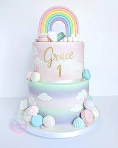 a multi - tiered cake decorated with pastel colors and rainbows