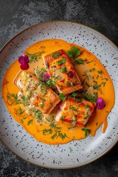 a white plate topped with fish covered in sauce