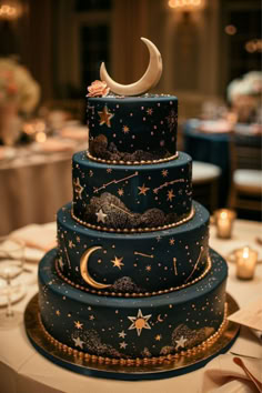 a three tiered blue cake with stars and moon decorations on it's sides