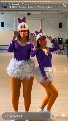 two women in purple and orange costumes posing for the camera