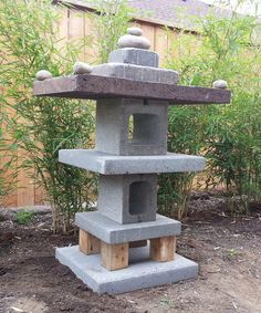 a stone sculpture sitting in the middle of a garden