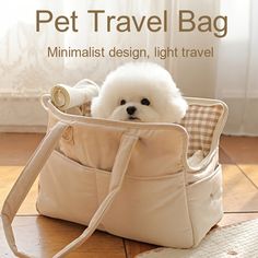 a small white dog sitting in a bag