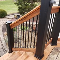 a wooden deck with black railing and hand rail