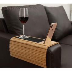 a glass of wine sitting on top of a wooden table next to a laptop computer