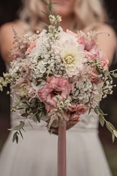 a bridal holding a bouquet of pink and white flowers