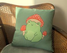 a green frog pillow sitting on top of a chair