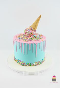 a birthday cake decorated with sprinkles and an ice cream cone on top