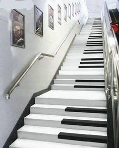 there is a stair case with black and white piano keys on the bottom half of it