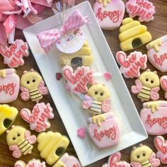 some decorated cookies are sitting on a plate next to pink flowers and other items that say happy birthday