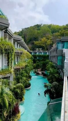 an outdoor swimming pool surrounded by trees and buildings