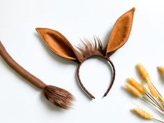 an animal ears headband next to some dried flowers