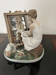 a figurine sitting on top of a table next to a mirror