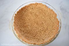 a pie crust in a glass dish on a marble counter