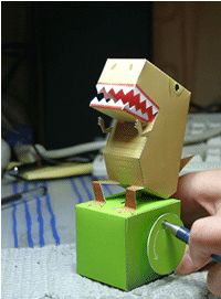 someone is making a paper toy that looks like a dinosaur