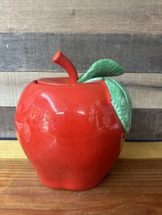 an apple shaped container sitting on top of a wooden table