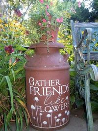 there is a large pot with flowers on it next to a bench and some plants