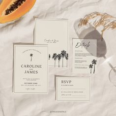 the wedding stationery is laid out on top of white paper and there are two pieces of fruit next to it