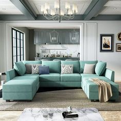 a living room with blue couches and pictures on the wall above it, along with a coffee table