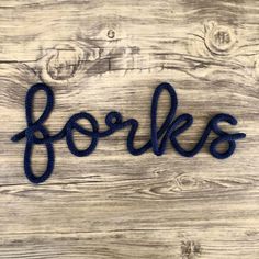 the word forkks is made out of blue yarn on a wooden background with wood planks