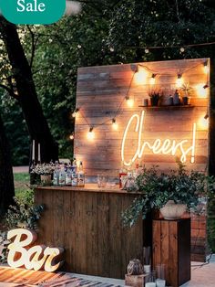 an outdoor bar is decorated with lights and greenery