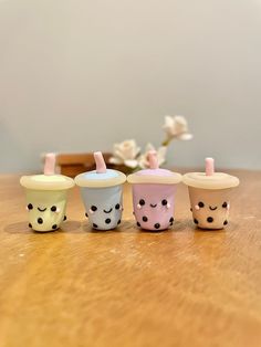 four small cups with faces painted on them