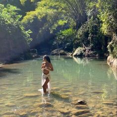 a woman standing in the middle of a river