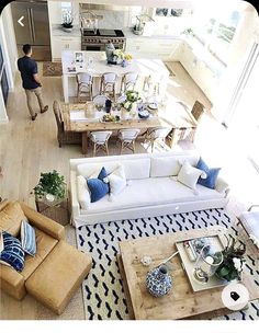 an overhead view of a living room and kitchen area with couches, chairs, coffee table