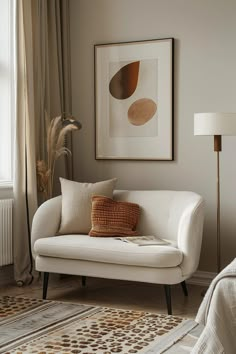 a white couch sitting next to a window in a living room on top of a rug