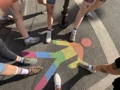 several people standing in the middle of a crosswalk with their legs crossed and feet up