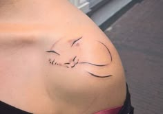 a woman's stomach with a small tattoo on the side of her belly that has a sleeping cat